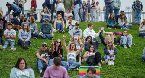 UNH Students and Families watching Football game from lawn