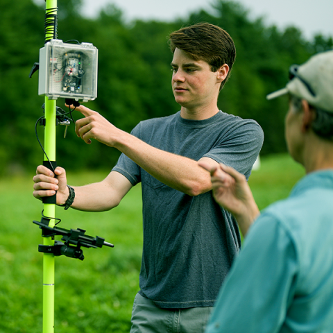 UNH student and professor using tool outside